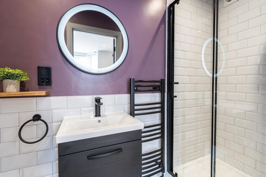 A modern bathroom featuring a sleek black vanit...