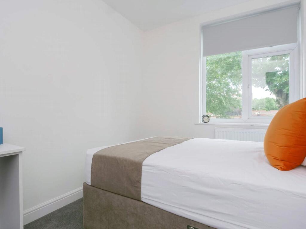 A bright and tidy single bedroom featuring a la...