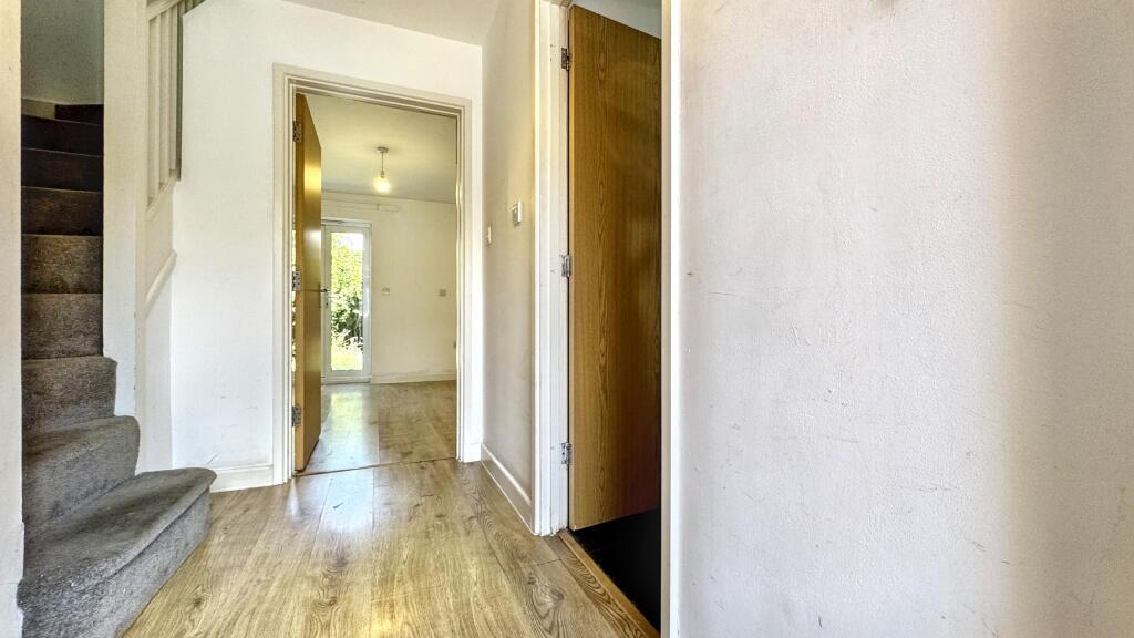 Bright hallway with wooden flooring and carpete...