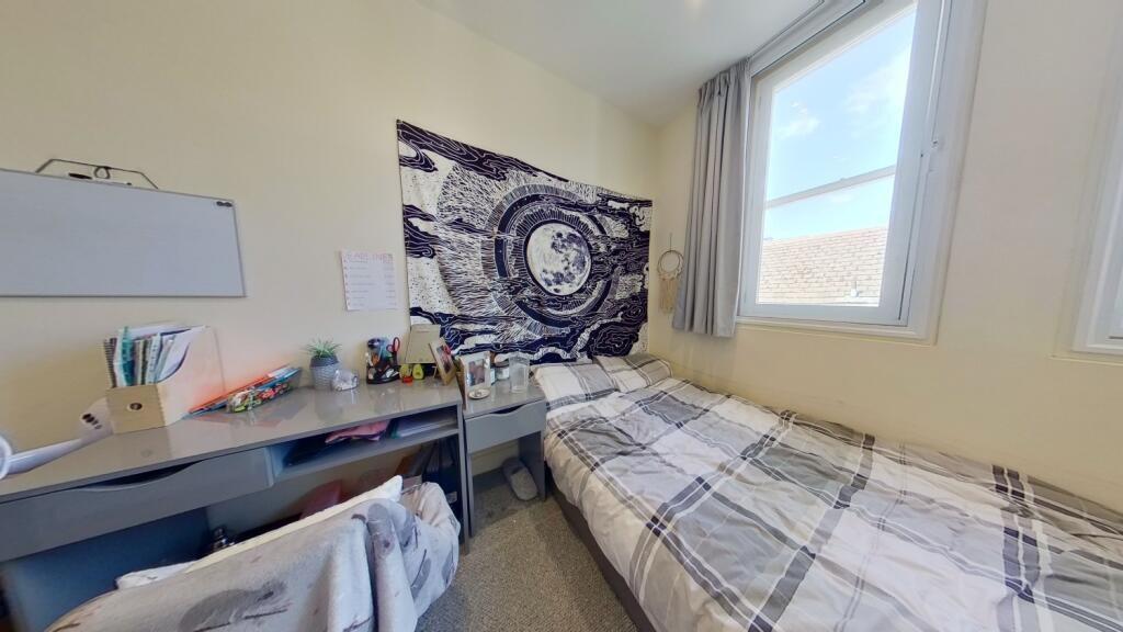 Bright and cozy student bedroom with a comforta...