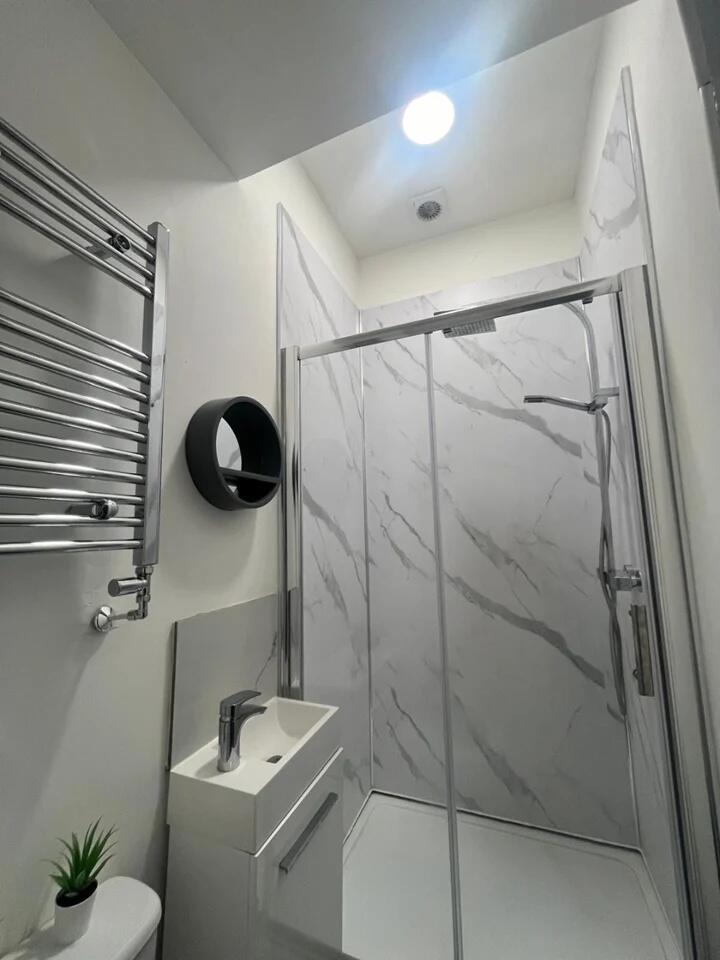 A modern bathroom featuring a sleek walk-in sho...