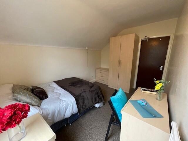 A cozy single bedroom featuring a comfortable b...