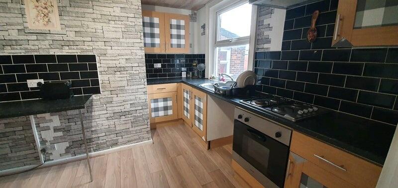 Modern kitchen with sleek black tiled backsplas...