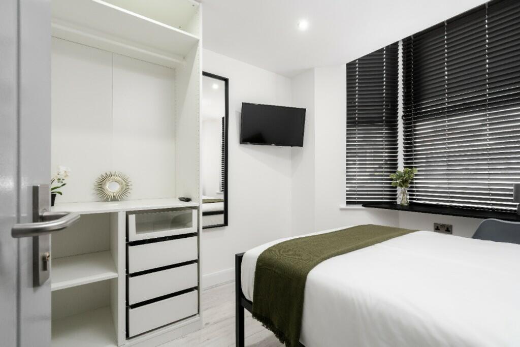 A modern and stylish double bedroom featuring a...