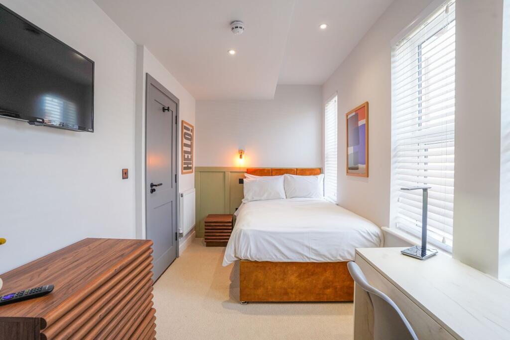 Bright and contemporary bedroom featuring a com...