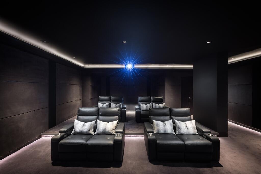 A sleek and modern private cinema room featurin...