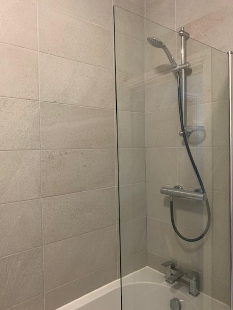 A modern bathroom suite featuring a clean, tile...