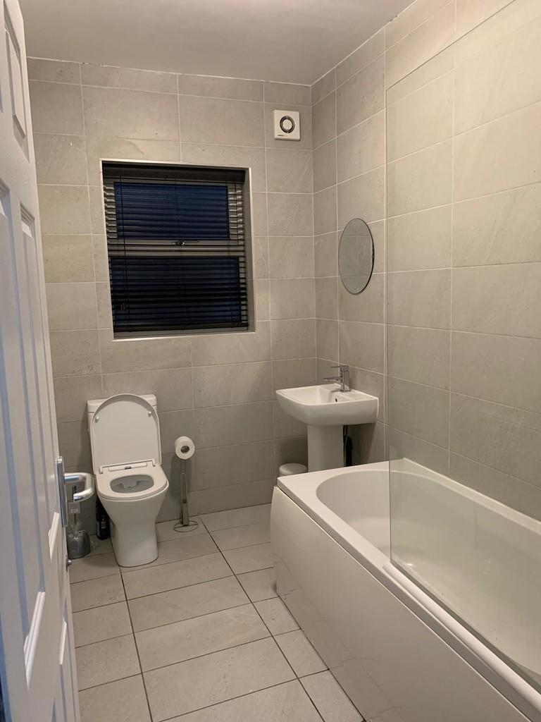 Bright and clean bathroom suite featuring a ful...