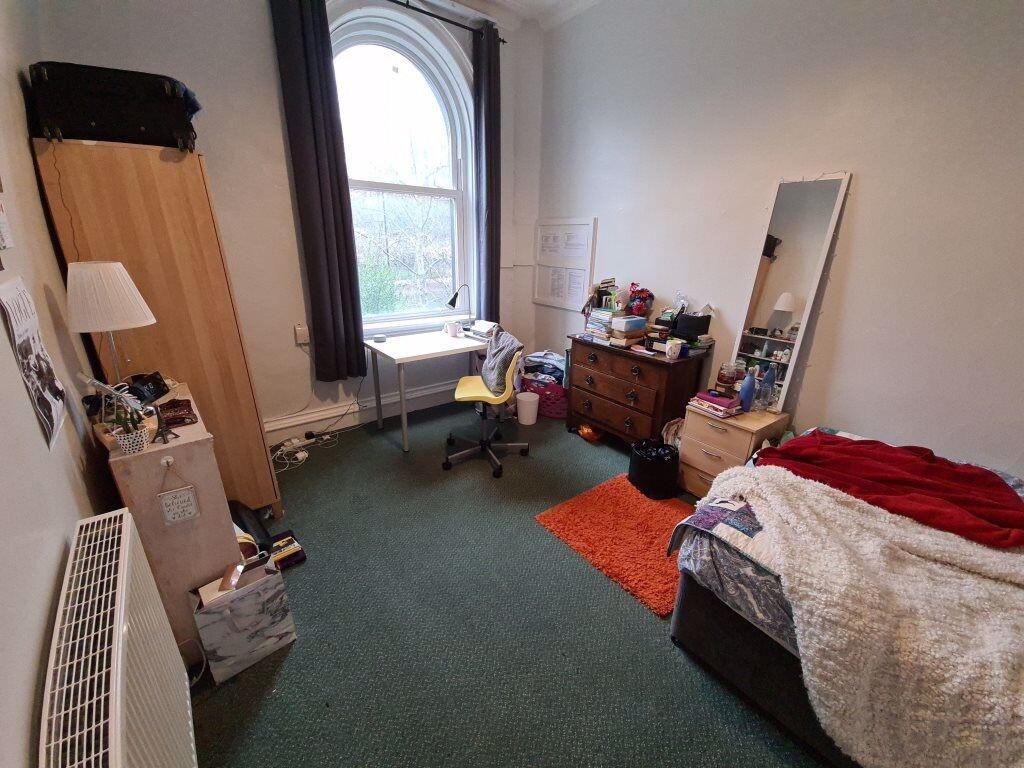 A compact, clean room featuring a single bed wi...