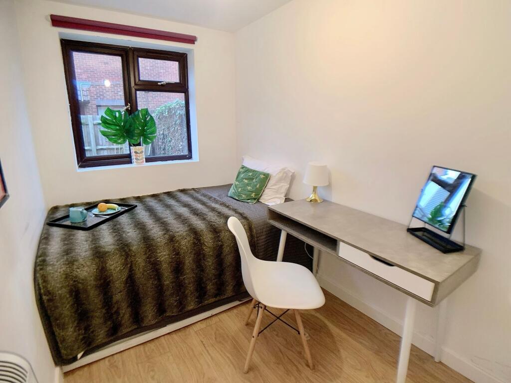 A cozy single bedroom featuring a comfortable b...