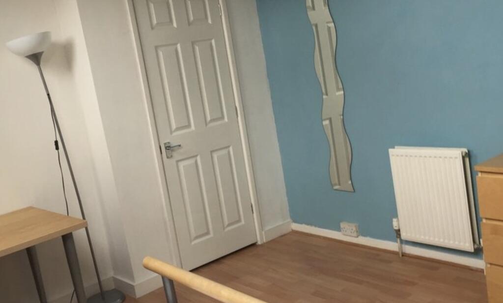 Neat bedroom with light blue feature wall, wood...